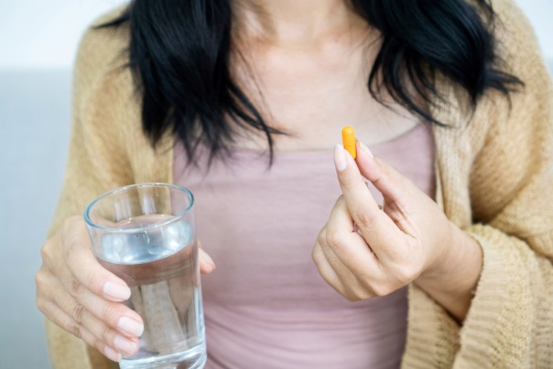 woman holding curcumin supplement